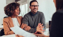 Couple souriant en train de signer un contrat