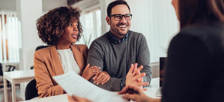 Couple souriant en train de signer un contrat