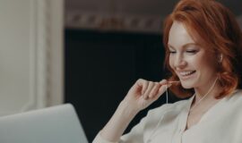 Femme souriante devant un ordinateur portable pour illustrer la gestion locative en ligne