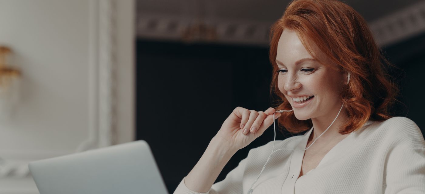 Femme souriante devant un ordinateur portable pour illustrer la gestion locative en ligne