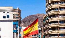 Un drapeau espagnol entre deux immeuble pour illustrer l'immobilier en Espagne