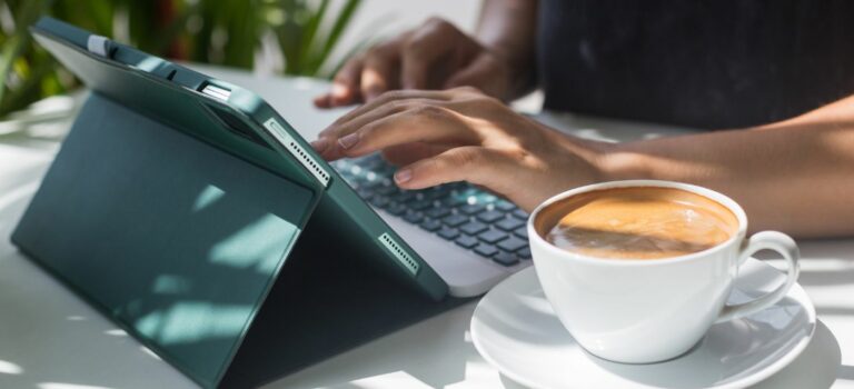 jeune femme devant son ordinateur portable et sa tasse de cafe