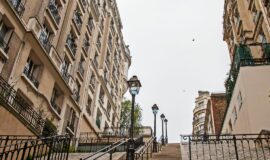 Rue typique de Montmartre avec un escalier et un ciel gris pour illustrer l'immobilier