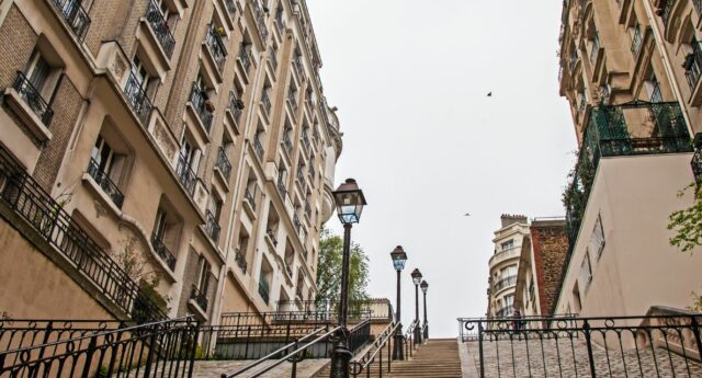 Rue typique de Montmartre avec un escalier et un ciel gris pour illustrer l'immobilier
