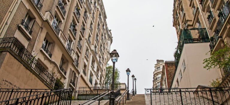 Rue typique de Montmartre avec un escalier et un ciel gris pour illustrer l'immobilier