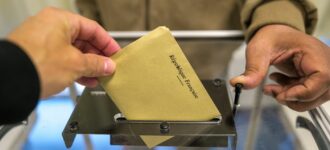 Personne en train de glisser son bulletin de vote dans l'urne pour les elections en France