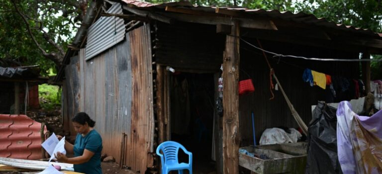 Rosa Romero vérifie les documents du tribunal de Jucuaran chez elle, sur la plage d'El Higueron, sur la côte du district de Jucuaran, au Salvador, le 20 juillet 2024. Des centaines de Salvadoriens pauvres risquent de perdre les maisons qu'ils ont construites il y a des décennies sur des terres publiques. La zone côtière attire désormais des investissements dans l'immobilier et le tourisme, une autre conséquence de la croisade anti-gang du président Nayib Bukele.