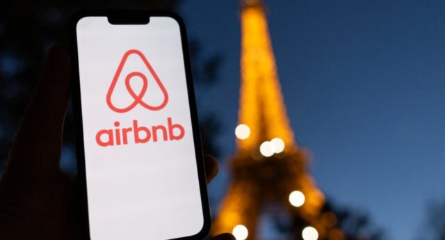 Smartphone avec le logo airbnb et la tour eiffel en toile de fond