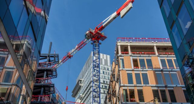 une grue a l'arret au milieu d'immeubles neufs ou en construction