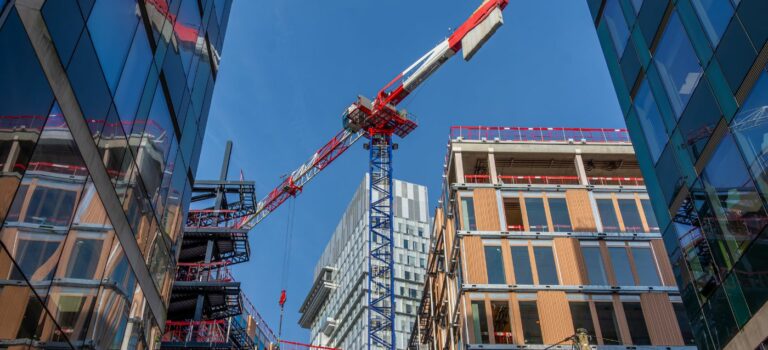 une grue a l'arret au milieu d'immeubles neufs ou en construction