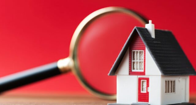 loupe posee sur une maison miniature pour illustrer l'estimation immobiliere