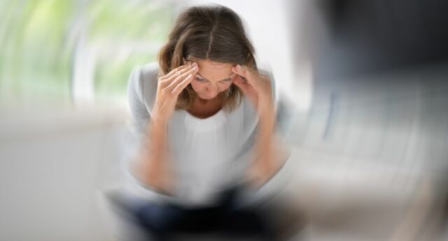 femme assis en tailleur lisant une lettre et se tenant la tete