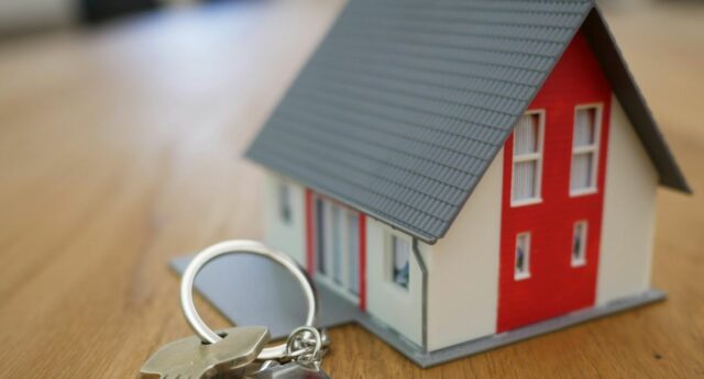 maison miniature et porte cle poses sur une table