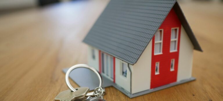 maison miniature et porte cle poses sur une table