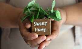 Femme sans papiers à Buena Park, Californie, touchee par la crise du logement à Los Angeles, posant avec un objet “Sweet Home” dans son salon.