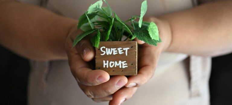 Femme sans papiers à Buena Park, Californie, touchee par la crise du logement à Los Angeles, posant avec un objet “Sweet Home” dans son salon.