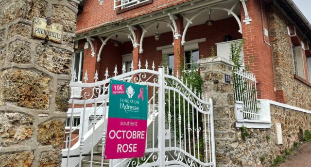 Reseau immobilier l’Adresse mobilise pour Octobre Rose 2025 avec un panneau solidaire devant une maison