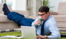 homme en teletravail travaillant sur son ordinateur portable depuis son salon
