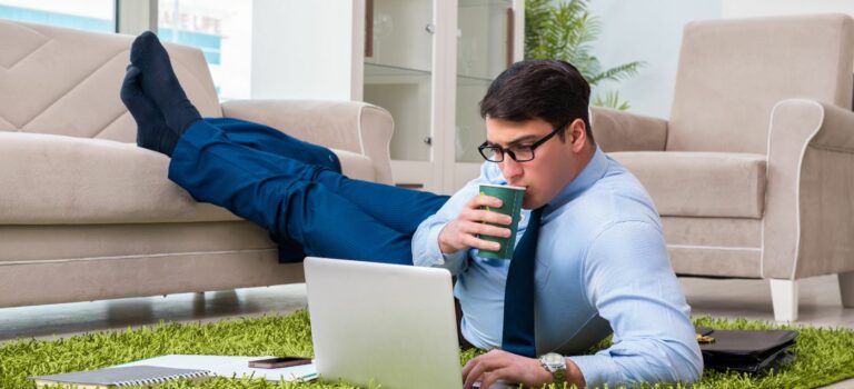 homme en teletravail travaillant sur son ordinateur portable depuis son salon