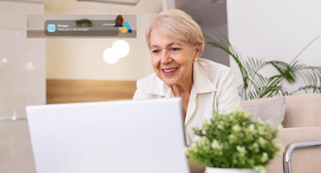 dame senior souriant devant son ordinateur pour illustrer pret viager hypothecaire arrago