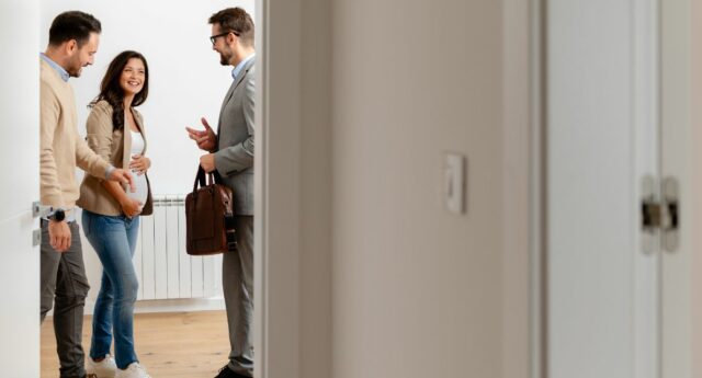 Couple attendant un enfant en visite d’appartement avec un agent immobilier