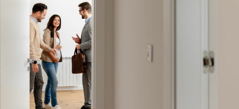 Couple attendant un enfant en visite d’appartement avec un agent immobilier