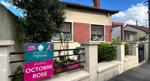 Panneau Octobre Rose de la Fondation l’Adresse affiché-e devant une maison individuelle, indiquant 10 euros reverses par panneau pose