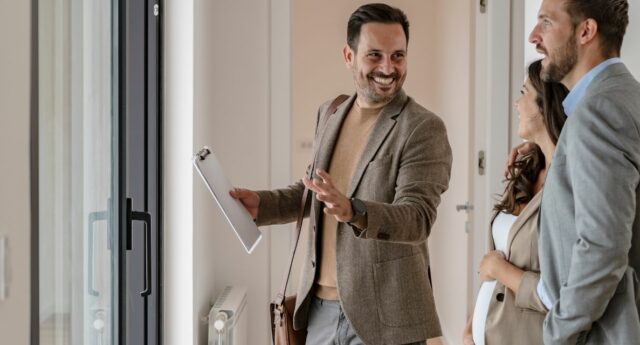 conseiller immobilier accompagnant un couple lors de la visite d'un logement