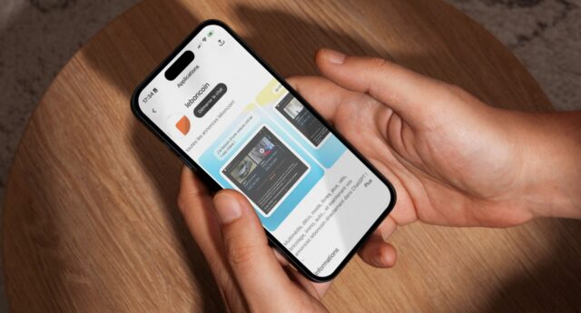 Ecran d'un iPhone 15 Pro Max tenu au-dessus d'une table en bois, affichant l'application leboncoin dans chatgpt