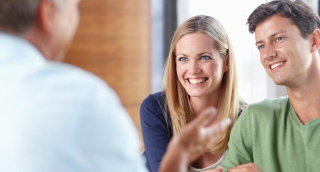 couple de jeunes, primo accedant souriant à leur banquier pour illustrer le credit immobilier