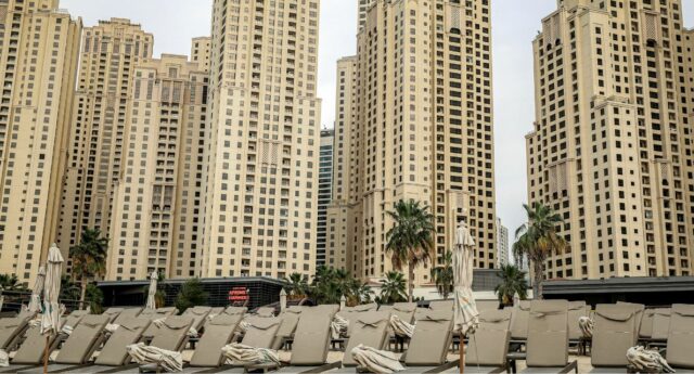 Plage avec transats vides à Dubai devant des tours residentielles