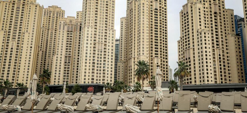 Plage avec transats vides à Dubai devant des tours residentielles