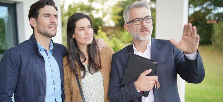Couple visitant une maison avec un agent immobilier lors d’un projet de residence secondaire en France