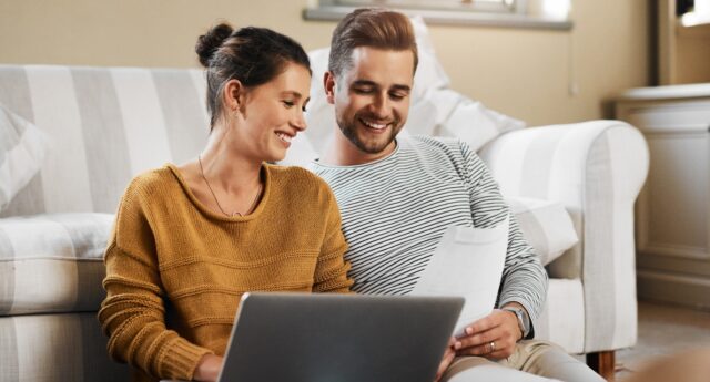 couple devant un ordinateur en train d'effectuer une recherche immobiliere