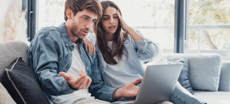 Couple regardant un ordinateur pour vendre leur maison sans agent immobilier