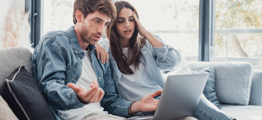 Couple regardant un ordinateur pour vendre leur maison sans agent immobilier