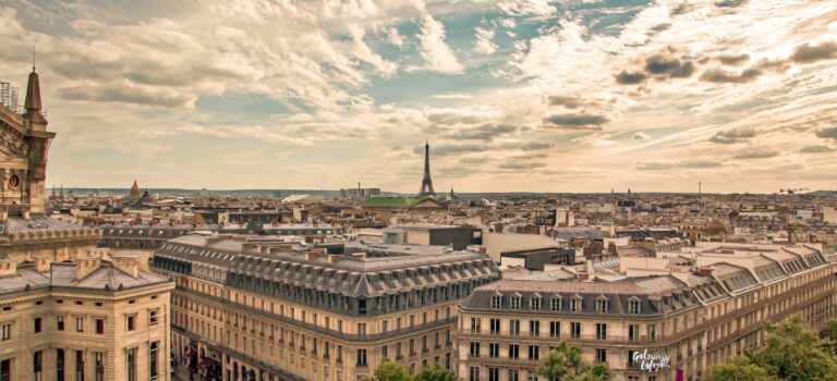 Vue aerienne Paris avec immeubles haussmanniens et tour eiffel au fond