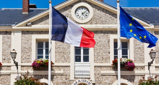 Facade d'une mairie en France avec drapeau tricolore et drapeau europeen