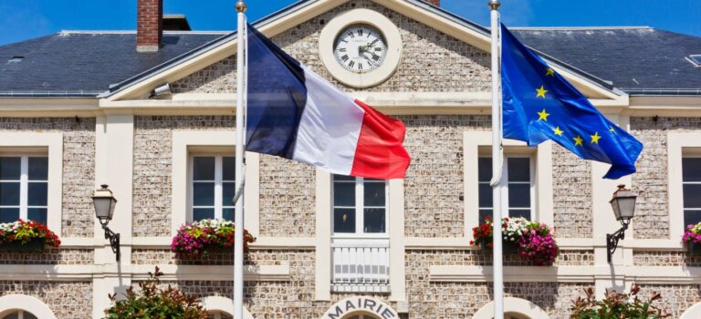 Facade d'une mairie en France avec drapeau tricolore et drapeau europeen