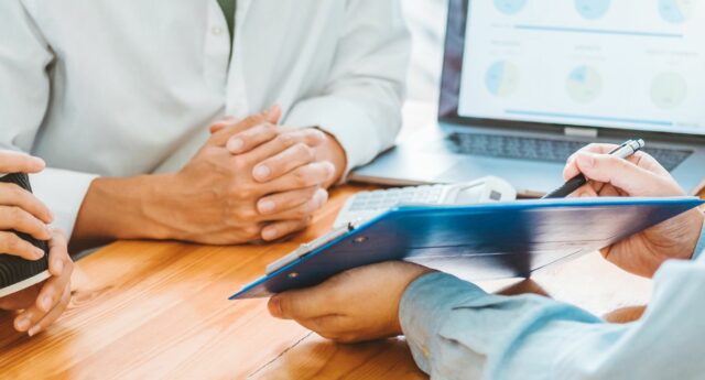 Couple d'emprunteurs face à leur conseiller bancaire lors d'un rendez-vous credit immobilier
