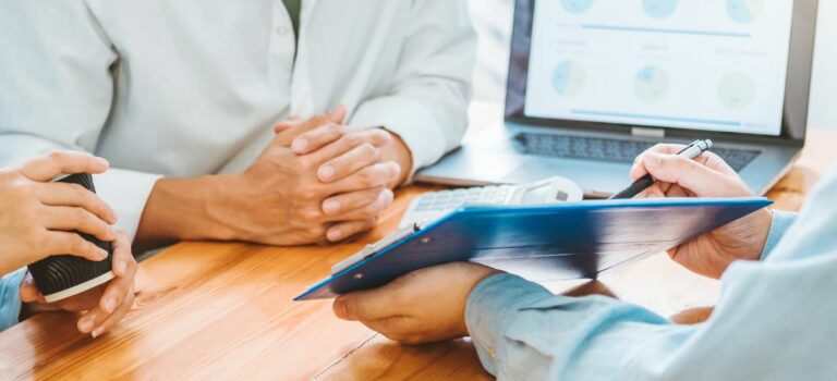 Couple d'emprunteurs face à leur conseiller bancaire lors d'un rendez-vous credit immobilier