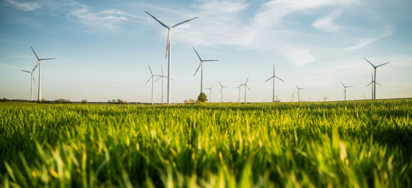 champ avec des eolienne pour illustrer electricite verte