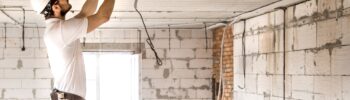 Electricien installant des câbles dans un logement en cours de renovation.