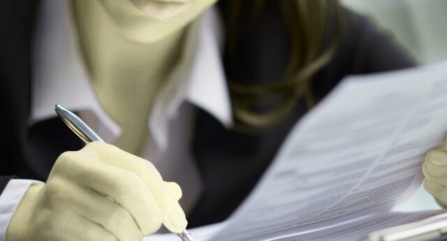 Femme examinant un contrat d’assurance de pret immobilier avant signature