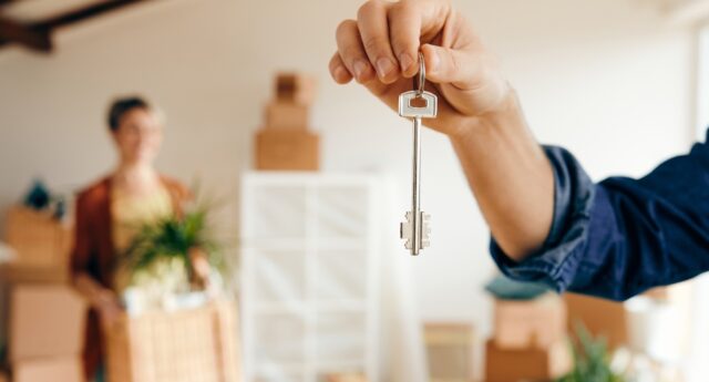 Un propriétaire remet les cles d’un logement à une locataire, illustration du choix entre location meublee et non meublee en 2026.