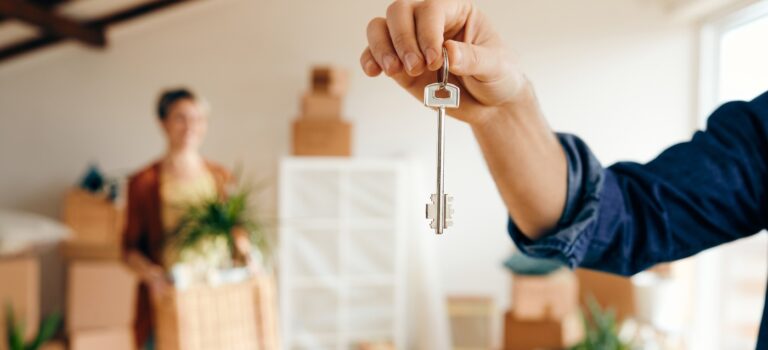 Un propriétaire remet les cles d’un logement à une locataire, illustration du choix entre location meublee et non meublee en 2026.