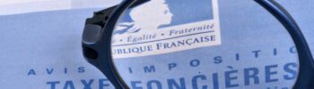 Avis de taxe fonciere avec une loupe posee dessus