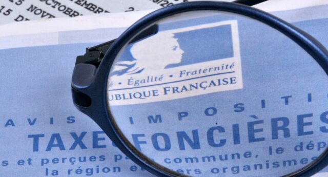 Avis de taxe fonciere avec une loupe posee dessus