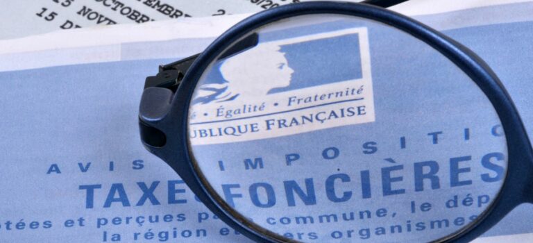 Avis de taxe fonciere avec une loupe posee dessus