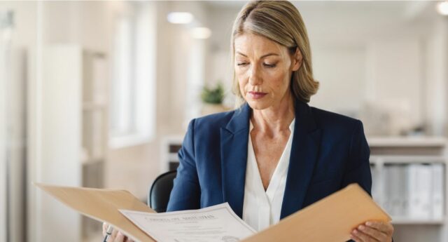 Directrice d’agence immobilière vérifiant l’attestation d’habilitation d’un négociateur immobilier